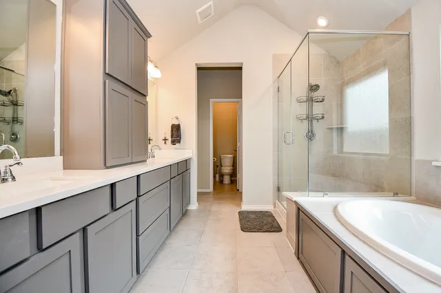 a spacious bathroom with a granite countertop tub sink a mirror a shower and vanity