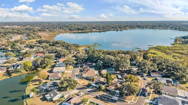 an aerial view of ocean and residential houses with outdoor space