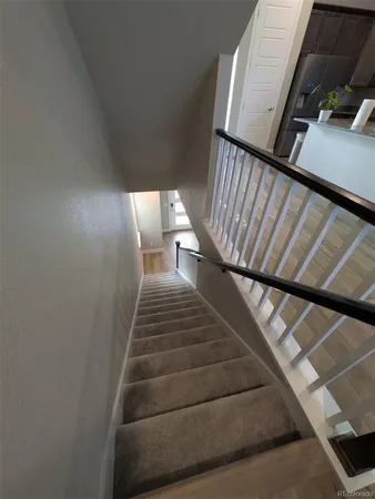 a kitchen with stainless steel appliances kitchen island granite countertop a refrigerator a stove a sink dishwasher and a dining table with wooden floor