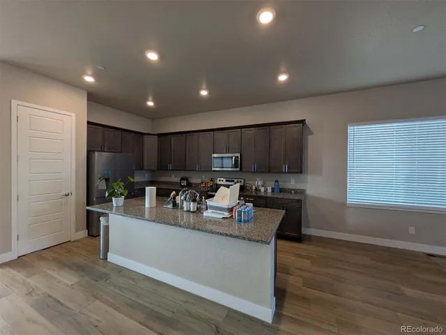 a kitchen with kitchen island granite countertop a sink stove and refrigerator
