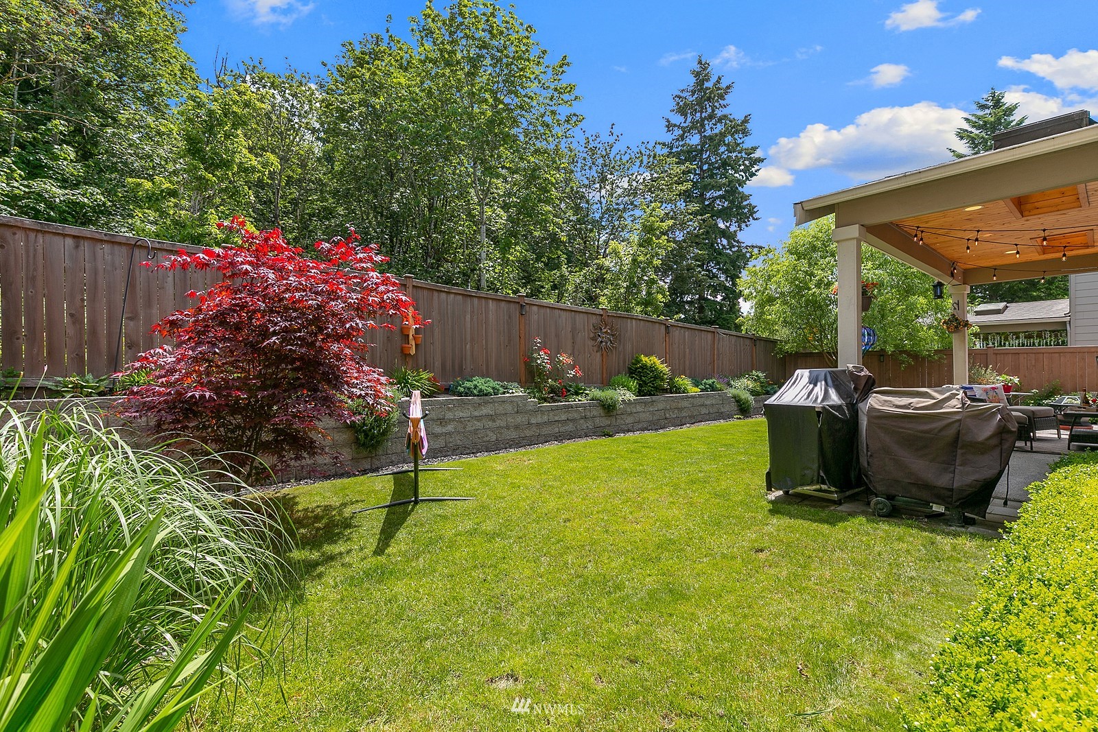14114 163rd Place Southeast Renton, WA 98059 - Photo 27 of 33 a view of a backyard with table and chairs potted plants and wooden fence