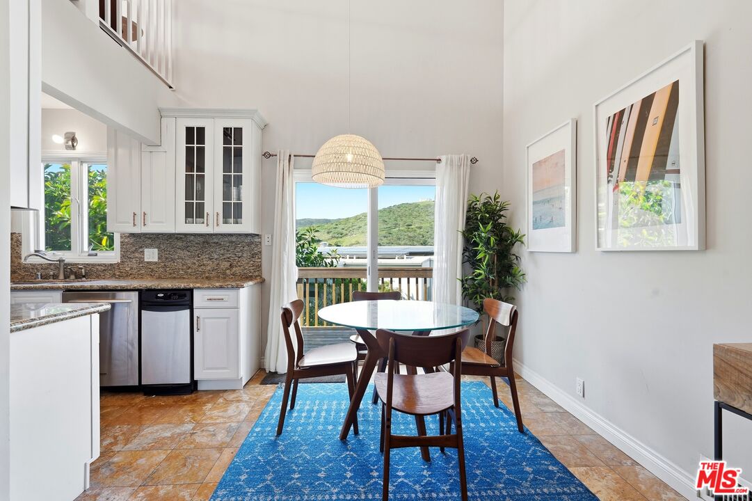 2955 Corral Canyon Road Malibu, CA 90265 - Photo 5 of 21 a dining room with a wooden table and chairs
