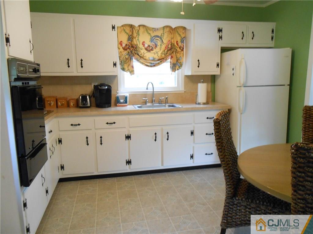4 Maple Road Iselin, NJ 08830 - Photo 5 of 21 a kitchen with stainless steel appliances a stove a refrigerator and white cabinets