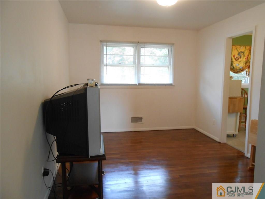 4 Maple Road Iselin, NJ 08830 - Photo 6 of 21 an empty room with wooden floor and windows