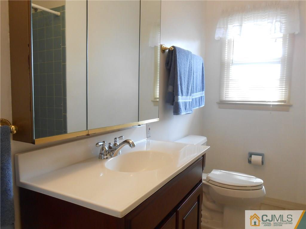 4 Maple Road Iselin, NJ 08830 - Photo 9 of 21 a bathroom with a sink a toilet and a mirror