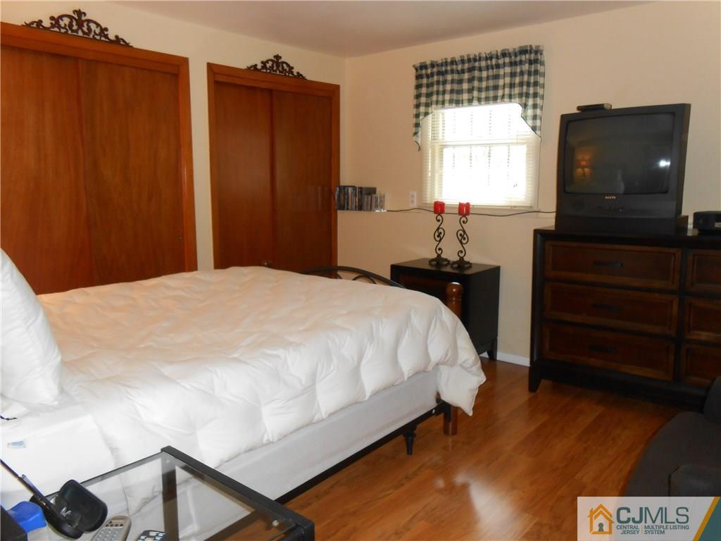 4 Maple Road Iselin, NJ 08830 - Photo 10 of 21 a bedroom with a bed and a flat tv screen