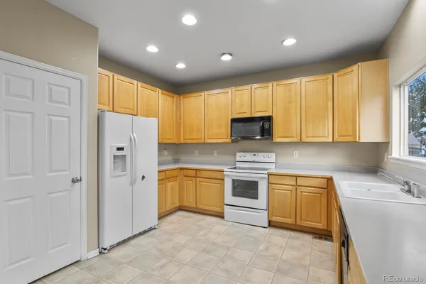 a kitchen with granite countertop cabinets stainless steel appliances and a window