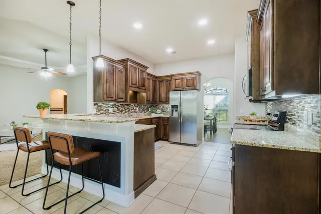 a kitchen with stainless steel appliances granite countertop a sink stove and microwave