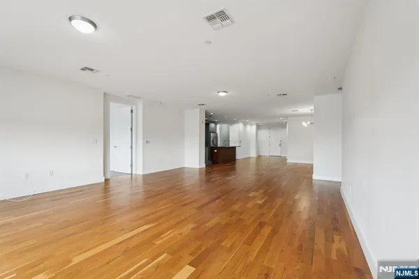 a view of empty room with wooden floor