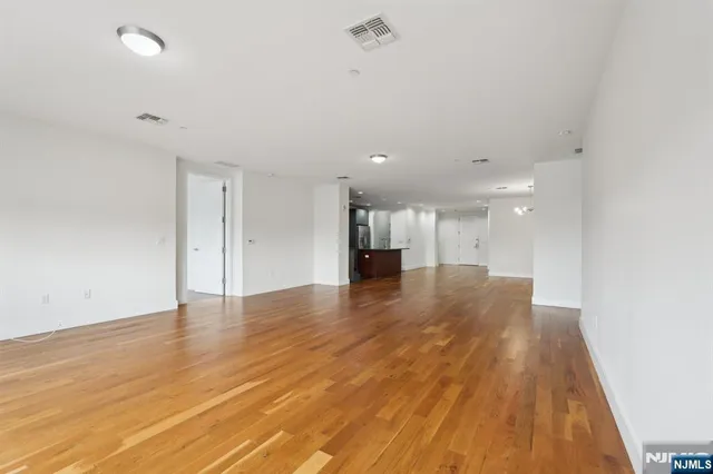 a view of empty room with wooden floor