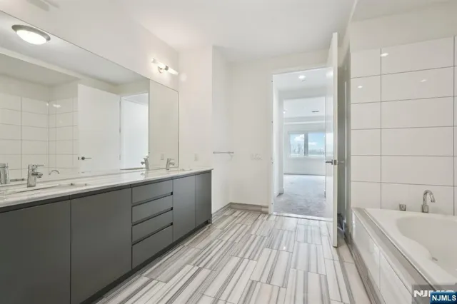 a bathroom with a double vanity sink and mirror with shower
