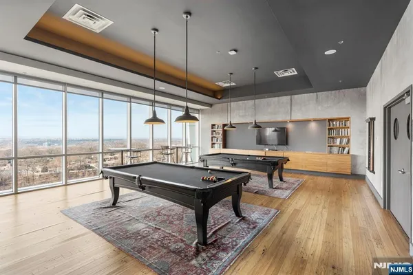 a living room with a table a rug and wooden floor