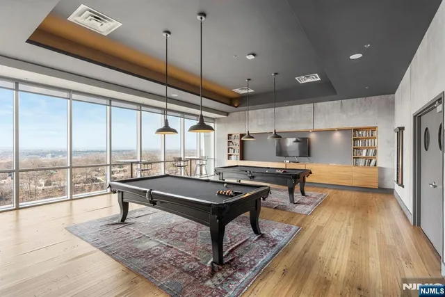 a living room with a table a rug and wooden floor