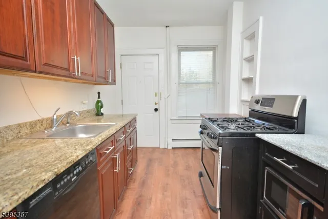 a kitchen with granite countertop a sink stove and cabinets