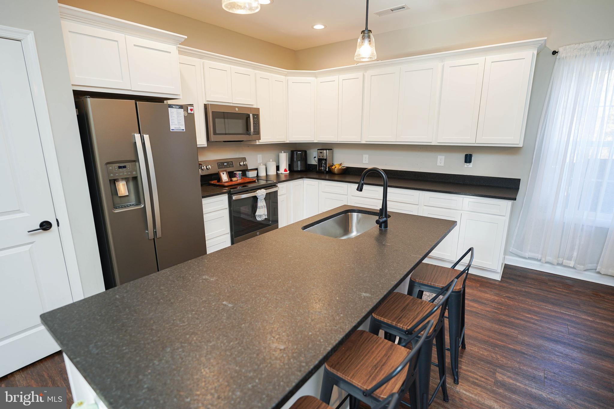2054 Groton Road Pocomoke City, MD 21851 - Photo 8 of 42 a kitchen with stainless steel appliances granite countertop a refrigerator a stove a sink a dining table and chairs
