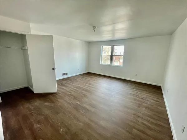 an empty room with wooden floor and closet