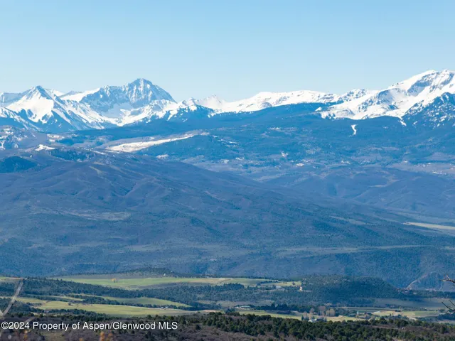 a view of a houses with a lush green forest