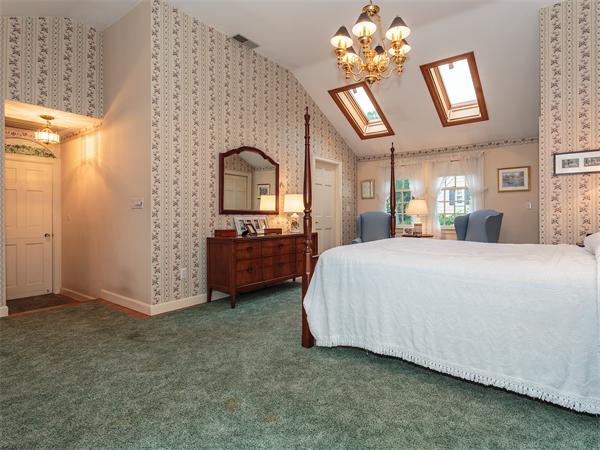 4 Robinhood Road Winchester, MA 01890 - Photo 11 of 26 a spacious bedroom with a bed and a chandelier