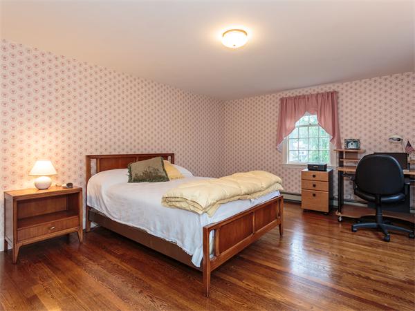 4 Robinhood Road Winchester, MA 01890 - Photo 14 of 26 a bedroom with a bed and wooden floor