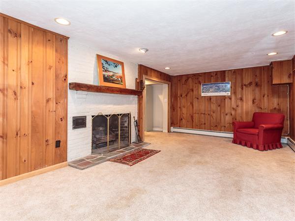 4 Robinhood Road Winchester, MA 01890 - Photo 17 of 26 a living room with furniture gym equipment and a fireplace