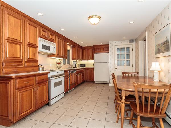 4 Robinhood Road Winchester, MA 01890 - Photo 8 of 26 a kitchen with stainless steel appliances granite countertop a stove a sink dishwasher a dining table and chairs with wooden floor