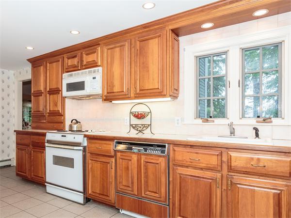 4 Robinhood Road Winchester, MA 01890 - Photo 9 of 26 a kitchen with stainless steel appliances granite countertop a sink and cabinets with wooden floor