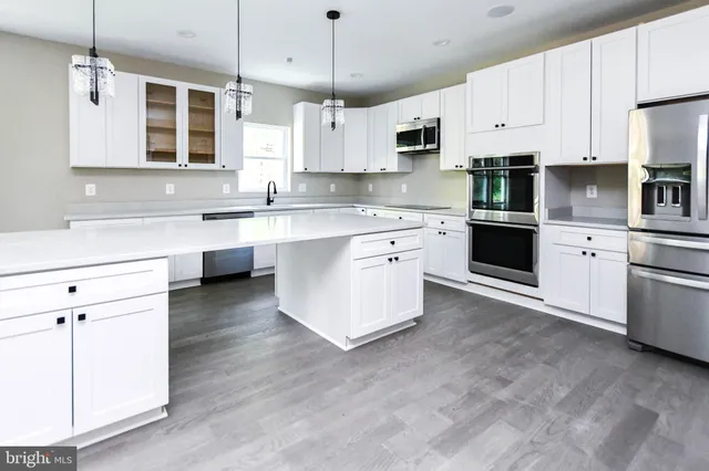 a kitchen with stainless steel appliances a refrigerator and a stove top oven