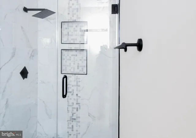 a view of an empty room with closet and a bathroom