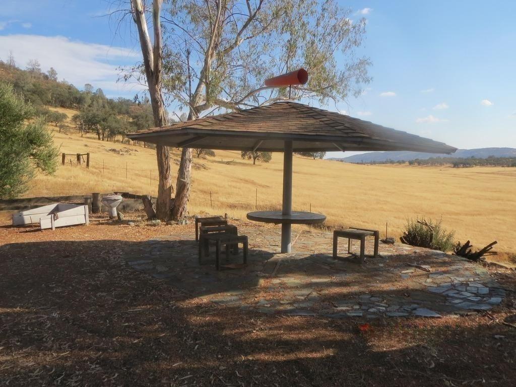 1172 Hodson Road Copperopolis, CA 95228 - Photo 73 of 94 a view of a lake with a table and chairs under an umbrella