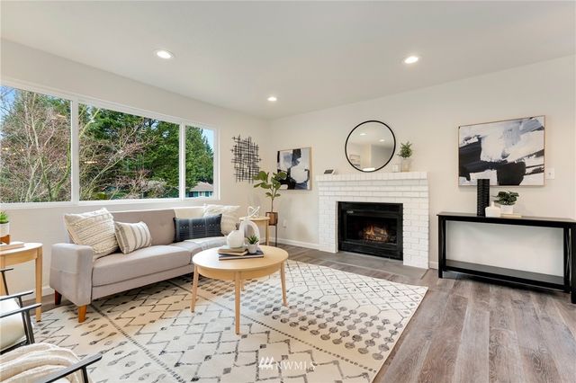 a living room with furniture a fireplace and a large window