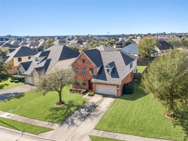an aerial view of a house with a yard and lake view