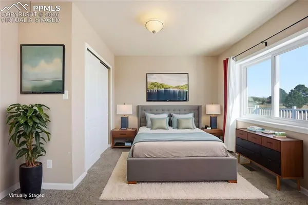 a bedroom with a large bed and a potted plant