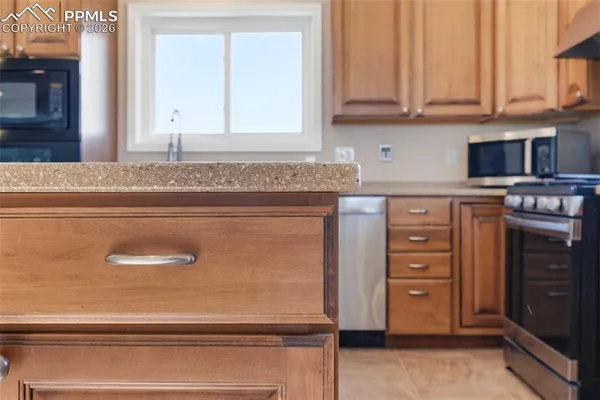 a kitchen with granite countertop a stove and a refrigerator