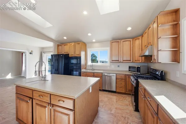 a kitchen with stainless steel appliances granite countertop a sink counter space cabinets and a large window
