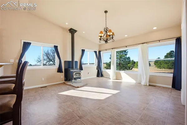 a view of an empty room with window and chandelier