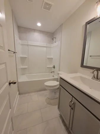 a bathroom with a granite countertop sink a toilet and shower