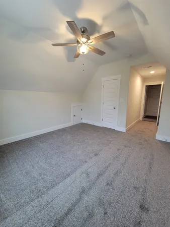 an empty room with a ceiling fan and a window