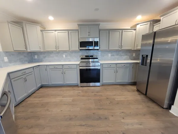 a kitchen with stainless steel appliances granite countertop a stove a sink and a refrigerator