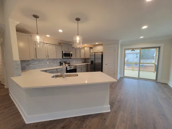 a large white kitchen with kitchen island a island in the center