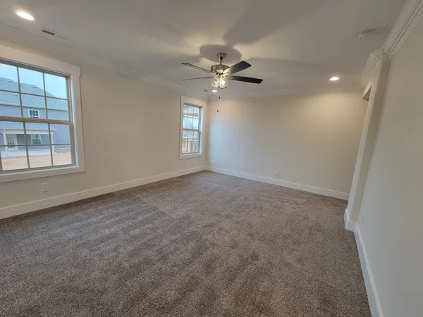 en empty room with windows and ceiling fan