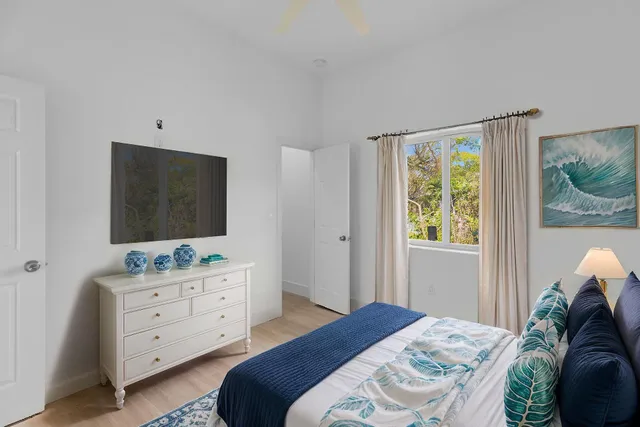 a bedroom with a bed and a flat tv screen on the dresser