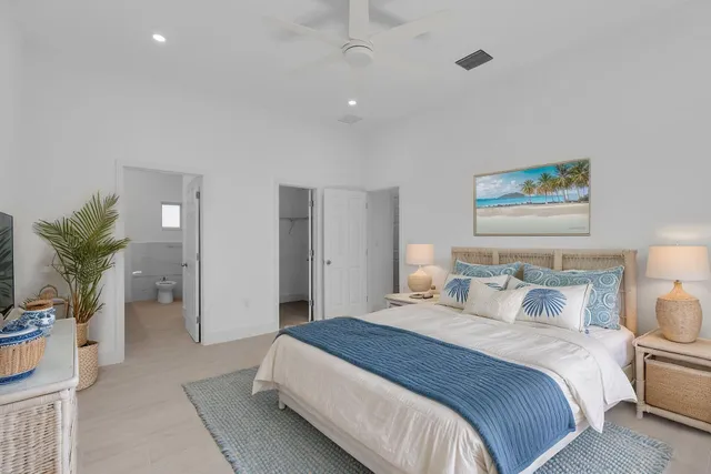 a bedroom with a large bed and a potted plant