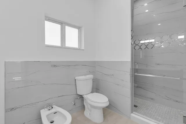 a bathroom with a toilet and a shower