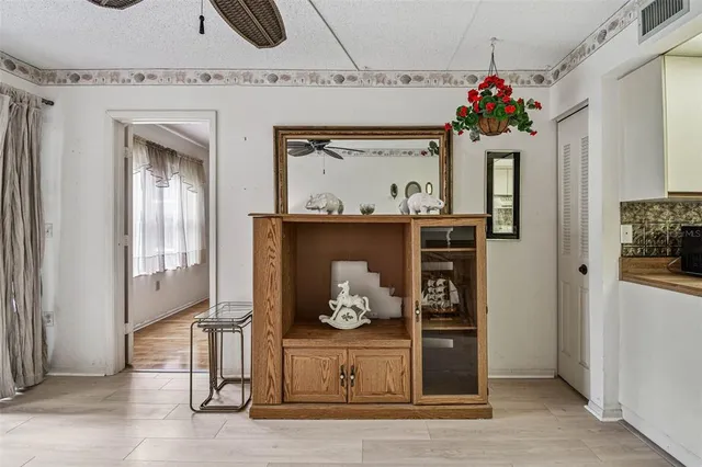 a view of a livingroom with furniture hardwood floor a ceiling fan and windows