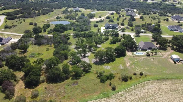 an aerial view of residential house with outdoor space and trees all around
