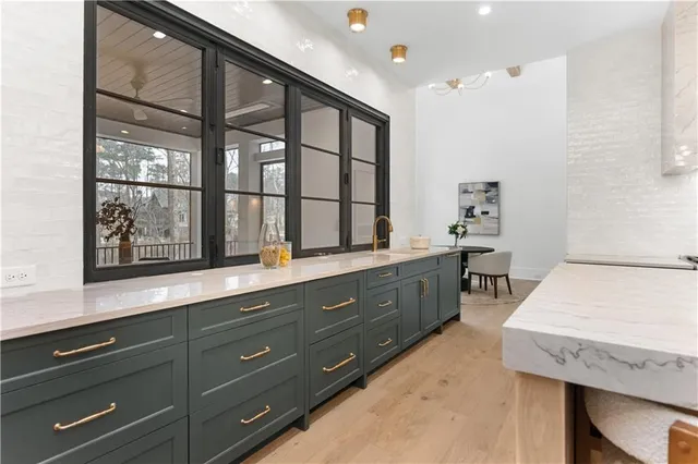 a large kitchen with granite countertop a sink dishwasher a dining table and chairs with wooden floor