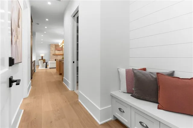 a view of a hallway to room with wooden floor and cabinet