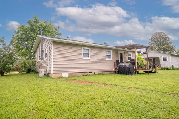 a view of a house with a patio and a yard