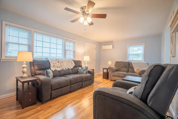a living room with furniture ceiling fan and a window