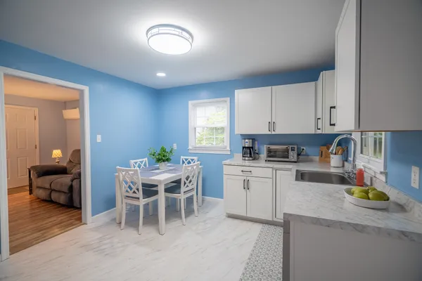 a kitchen with a dining table chairs and white appliances